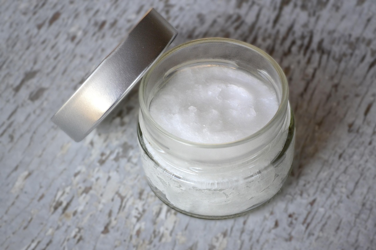 Coconut oil in a clear glass jar, the kind of plain, food-grade oil this guide compares against sunflower and olive oil.