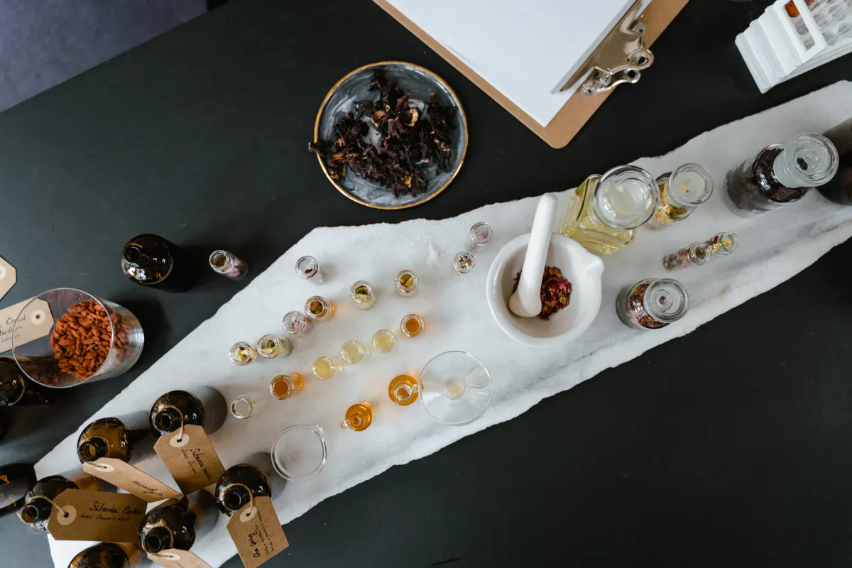 Glass bottles filled with yellow and orange liquid, styled the way many natural hair oil brands market their products.